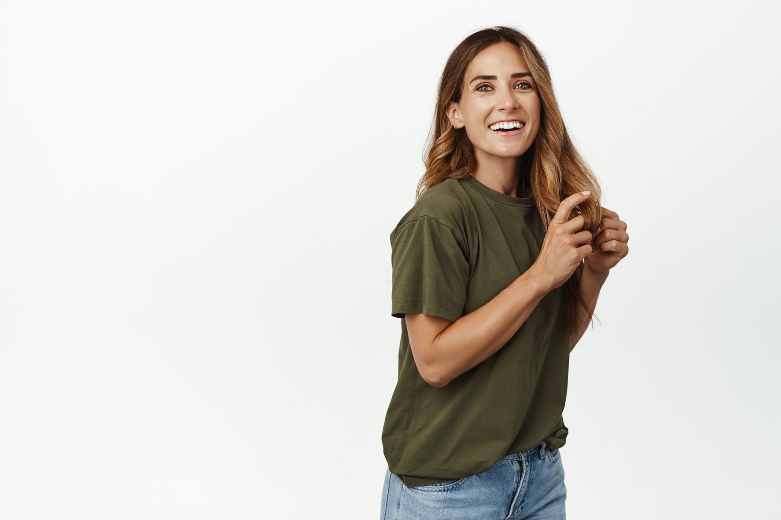 Beautiful middle aged woman with long healthy hair, smiling white teeth, laughing and looking happy at camera, wear casual t-shirt with jeans, studio background.